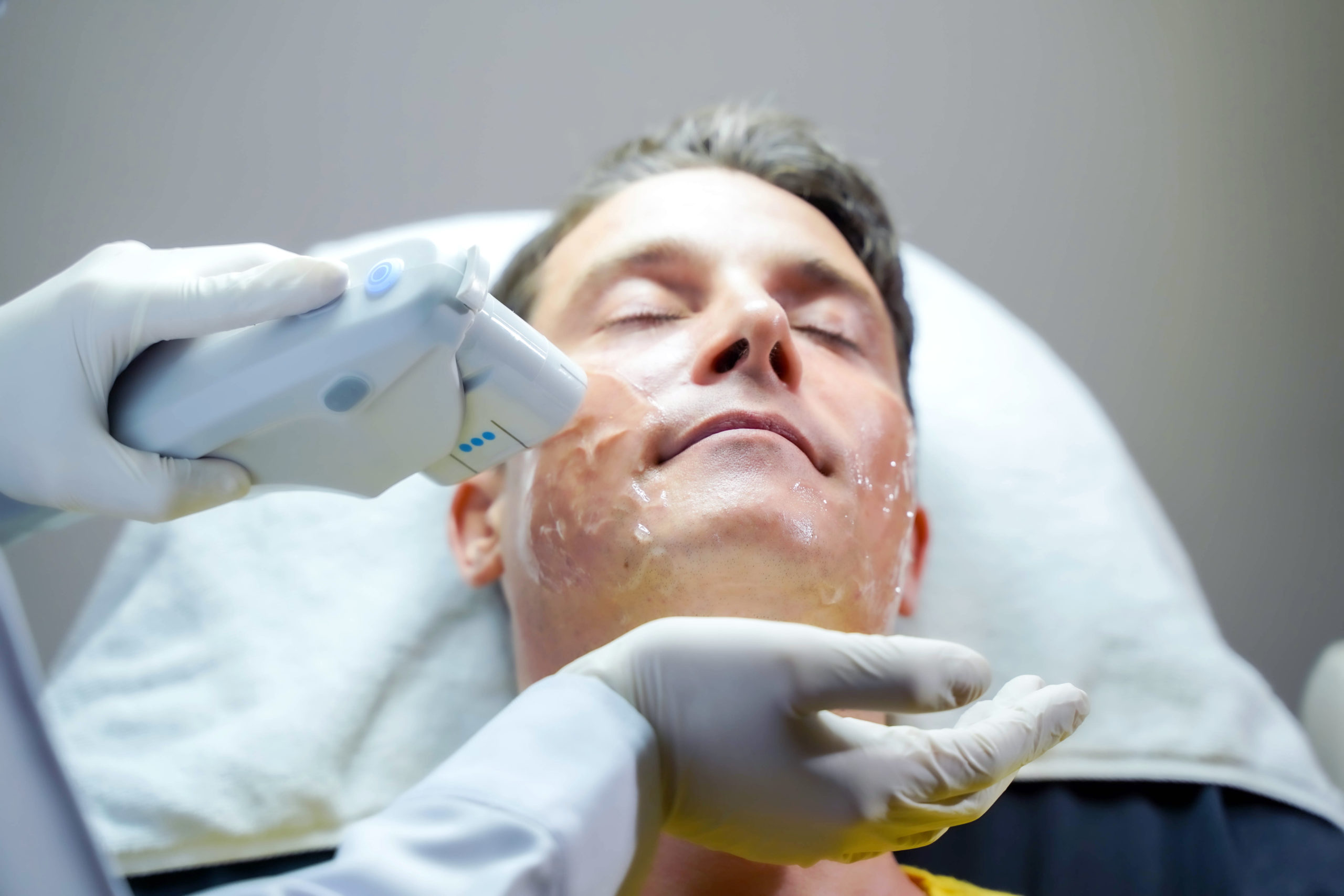 hombre guapo primer plano que tiene terapia luz color estimular piel facial scaled Tratamiento Ultherapy Madrid